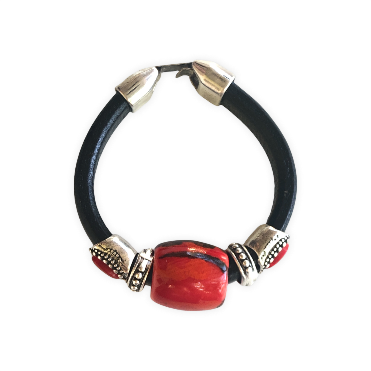 Elegante pulsera de cuero regaliz, con cuentas de Zamak con baño de plata y una espectacular cuenta de cerámica roja y negro. Combínala con tus prendas de diario. Superior