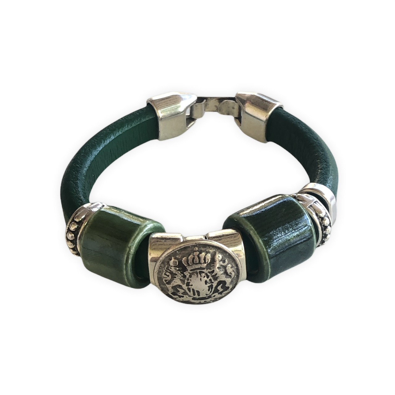 Elegante pulsera de cuero regaliz, con cuentas de Zamak con baño de plata y una espectacular cuenta de cerámica verde. Combínala con tus prendas de diario.